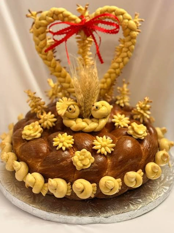 Каравай с плетёным сердцем, колосьями и красной лентой на подносе