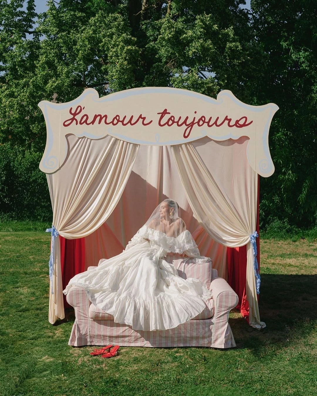 Невеста на диване под сценой-домиком с надписью L'amour toujours